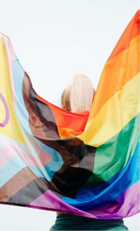 woman holding LGBTQ+ flag